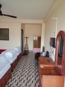 a room with two beds and a television and a tripod at Sauraha Inn in Sauraha