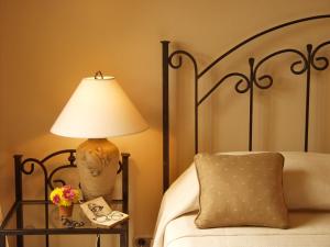 a lamp sitting on a table next to a bed at Los Robles Charming Colonial Boutique Hotel in Managua