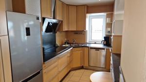 eine Küche mit Holzschränken und einem Edelstahlkühlschrank in der Unterkunft 8-10 Personen Maisonette Wohnung mit 3,5 Schlafzimmern in Wörrstadt