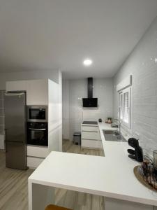 a kitchen with white appliances and a white counter top at Apartamento Vitelio in Carmona