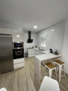 a kitchen with white appliances and a white counter top at Apartamento Vitelio in Carmona +19 photos