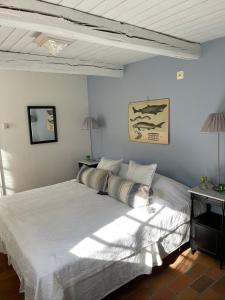 a bedroom with a large white bed and two lamps at Östangård Apartments in Skillinge