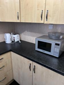a kitchen with a microwave and a bowl on a counter at NICE HOUSE Families contractors in Birmingham