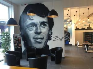 Un grande ritratto di un uomo su un muro in un ristorante di Midi 81 HOSTEL a Bruxelles