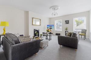 a living room with couches and chairs and a fireplace at The Heart of Brixham, Bolton Plaice, Luxury Apartment in Brixham