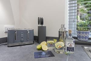 a kitchen counter with a toaster and a bottle of alcohol at The Heart of Brixham, Bolton Plaice, Luxury Apartment in Brixham