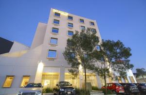 莫雷利亚莫雷利亚图罗特尔酒店的一栋白色建筑，前面停着汽车