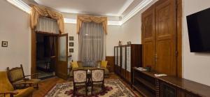 a living room with a television and a room with a table at Moods Apartmans in Szeged