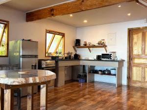 a large kitchen with a table and a refrigerator at Vaima Waterfront Bungalow in Punaauia