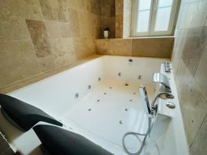 a white bath tub with a faucet in a bathroom at Maison de ville avec spa privé in Courseulles-sur-Mer +14 photos