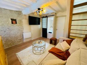 a living room with a couch and a table at Maison de ville avec spa privé in Courseulles-sur-Mer