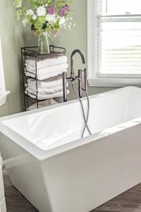 a bathtub with a sink and a vase of flowers at waterfront Lake Greenwood boat launch king beds hot tub fire pit sun sets pellet grill private peninsula in Chappells +5 photos
