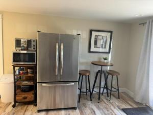 a stainless steel refrigerator in a kitchen with stools at Cozy Harborside Condo, Florence in Florence