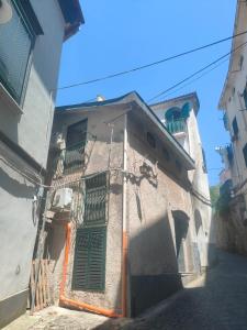 an old building with green shutters on a street at CasaFiore Guest House in Vietri sul Mare