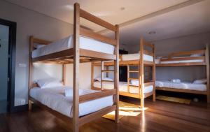 two bunk beds in a room with wooden floors at Villa Caparica Hostel in Costa da Caparica +22 photos