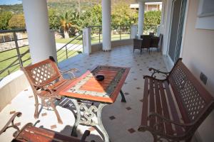 a patio with two benches and a table on a porch at Villa Eva στην περιοχή Ερέτρια in Eretria