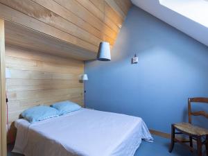 a bedroom with a white bed and a chair at Maison typique 6 pers, proche Peyragudes et Loudenvielle - FR-1-695-70 in Loudenvielle