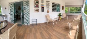 a room with chairs and a table on a wooden floor at Granja Vale das Águas in Igarassu