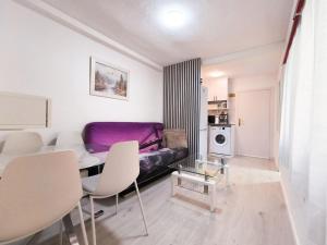 Una sala de estar con un sofá, una mesa y sillas. en Corazon Benidorm Heart Benidorm, en Benidorm