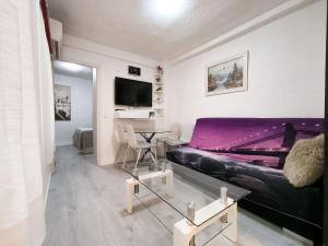 Sala de estar con cama morada y mesa en Corazon Benidorm Heart Benidorm, en Benidorm