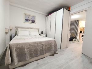 Un dormitorio blanco con una cama y un armario. en Corazon Benidorm Heart Benidorm, en Benidorm
