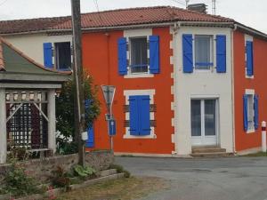una casa colorata con persiane blu su una strada di Charmant gîte à Saint-André-Goule-d'Oie proche Puy du Fou - FR-1-426-570 a Saint-André-Goule-dʼOie
