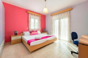 a bedroom with a bed and a pink wall at villa de calme in Pastida +10 photos