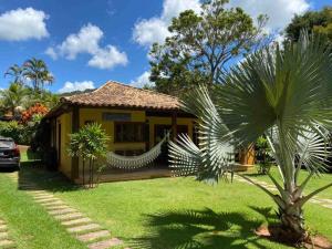 a house with a palm tree in front of it at Um Sonho Casa - Secretário RJ in Araras Petropolis