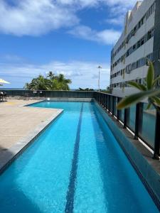 a large blue swimming pool next to a building at Beach Class International - Beira Mar - Boa Viagem in Recife