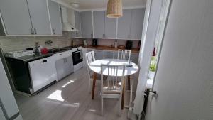 a kitchen with white cabinets and a table and chairs at Gula Villan apartment in Västervik