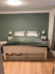a bedroom with a large bed with a green blanket at Ferienwohnung Barbara in Kirchhundem