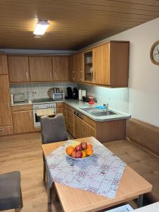 a kitchen with a table with a bowl of fruit on it at Ferienwohnung Barbara in Kirchhundem