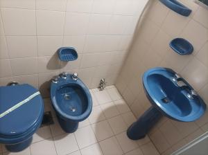 a bathroom with a blue toilet and a sink at Hotel Americano in Buenos Aires +36 photos