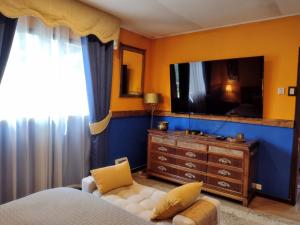 a bedroom with a bed and a tv and a dresser at Casa costa Panitao, Puerto Montt in Puerto Montt