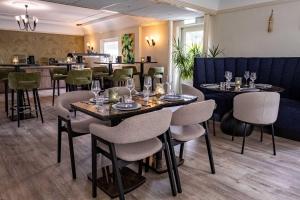a restaurant with tables and chairs and a bar at Strandhotel de Logerij Renesse in Renesse