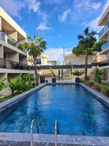 a swimming pool in the middle of a building with palm trees at No 22 Çeşme in Çeşme