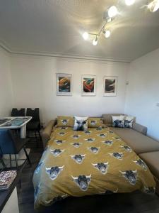 a bedroom with a bed and a table and chairs at Stonehaven Centre - Dunnottar Apartment in Stonehaven +13 photos