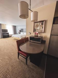 a hotel room with a desk and a bed at Staybridge Suites Marquette by IHG in Marquette