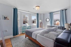 una camera da letto con un letto, un divano e finestre di Luxury 8 Bedroom House, Steps to Tropicana, Beach and Boardwalk! ad Atlantic City