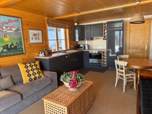 a living room with a couch and a table in a kitchen at Luxury chalet in Les Diablerets Villars ski area in Les Diablerets