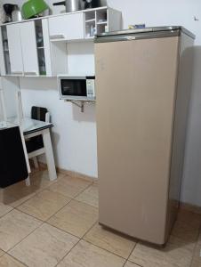 a white refrigerator in a kitchen with a table at Casa completa Estância Turística de Ribeirão Pires in Ribeirão Pires