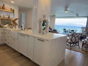 a white kitchen with a view of the ocean at Unforgettable Oceanfront Stay , Nature, Luxury & Tranquility in Kahana