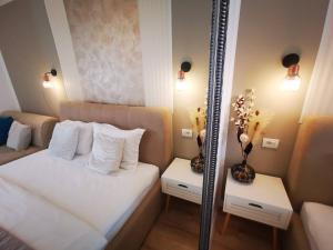 a bedroom with a mirror and a bed with white pillows at ALDIRA Studio Arena Nationala in Bucharest