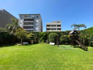 a park with a bench in the grass with buildings at Tigre Center Tower F - seguridad 24hs - cochera incluida in Tigre