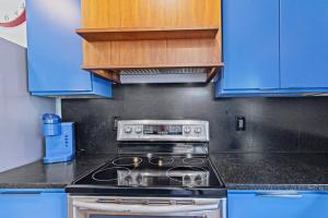cocina con fogones y armarios azules en Indy Stadium Villa 711 L, en Indianápolis 18 fotos más