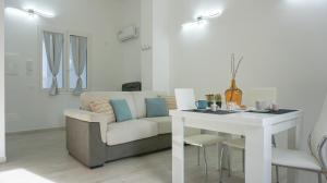 ein Wohnzimmer mit Sofa und Tisch in der Unterkunft Hampsicora Apartment in Alghero + 8 Fotos
