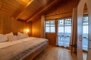 a bed in a room with wooden walls and windows at Ferienhaus Elfi in Abtenau