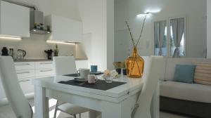 eine weiße Küche mit einem Esstisch und Stühlen in der Unterkunft Hampsicora Apartment in Alghero