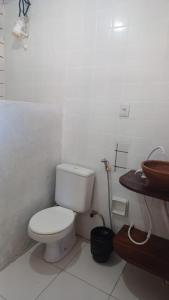 a white bathroom with a toilet and a sink at Mar Sereno Pousada pé na areia in Santa Cruz Cabrália