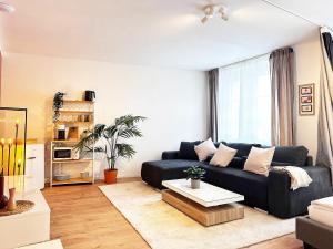 a living room with a black couch and a table at 70qm Apartment in Viersen mit 3 Betten zentral gelegen mit hohen Decken - BEUYS Apartments - Viersen in Viersen